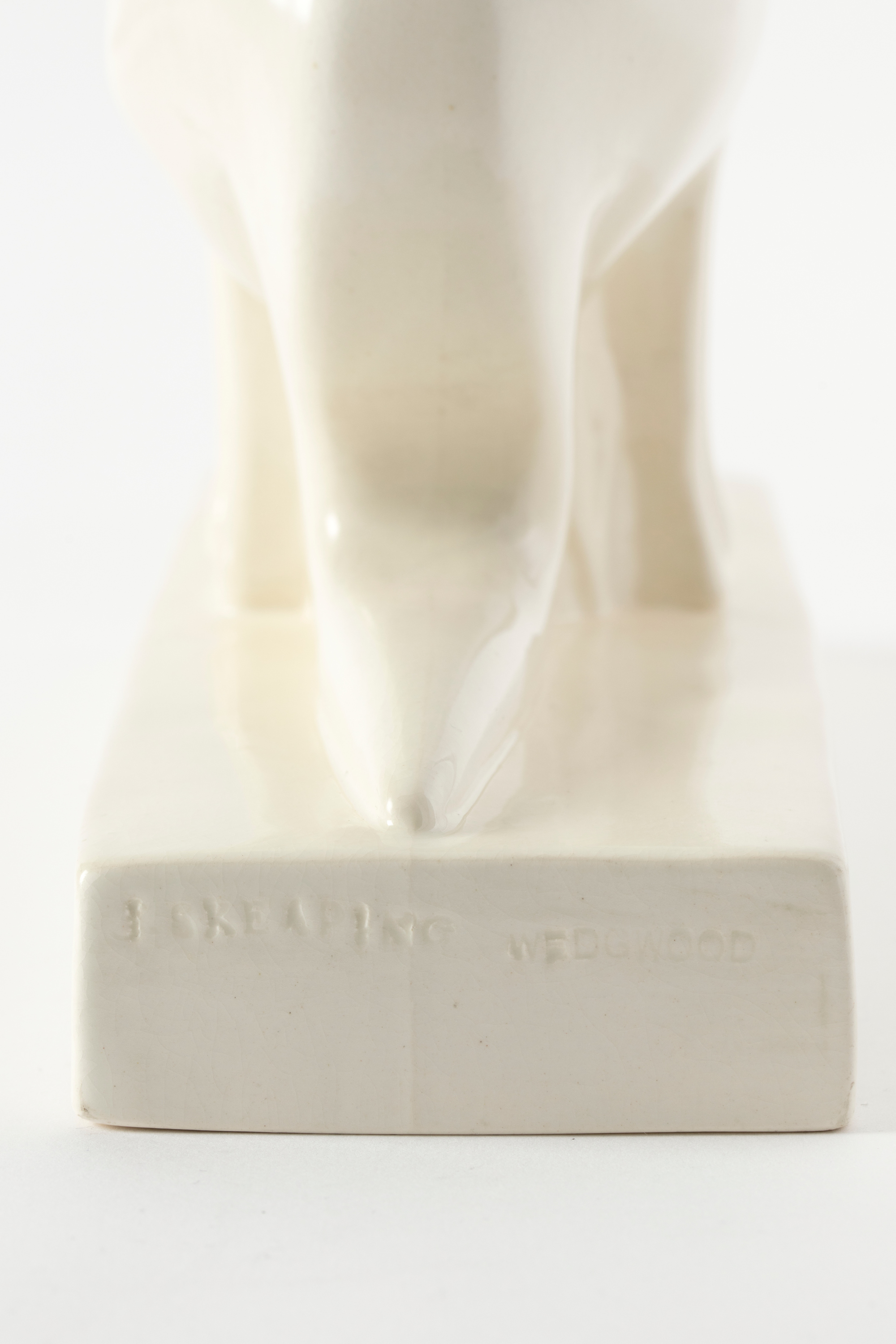 Rectangular base of a white earthenware figure showing the imprinted text ‘J SKEAPING / WEDGWOOD’.